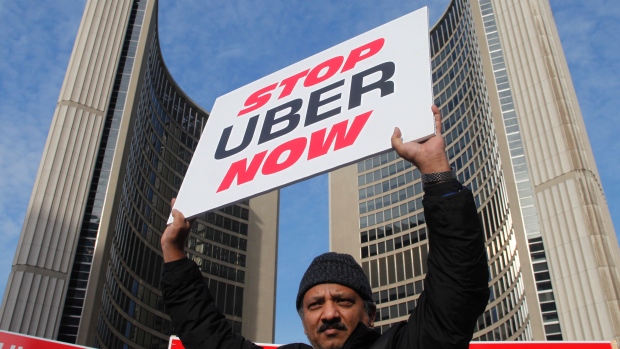 A taxi driver protests in front of city hall against the Uber ridesharing car service in Toronto December 9, 2015.