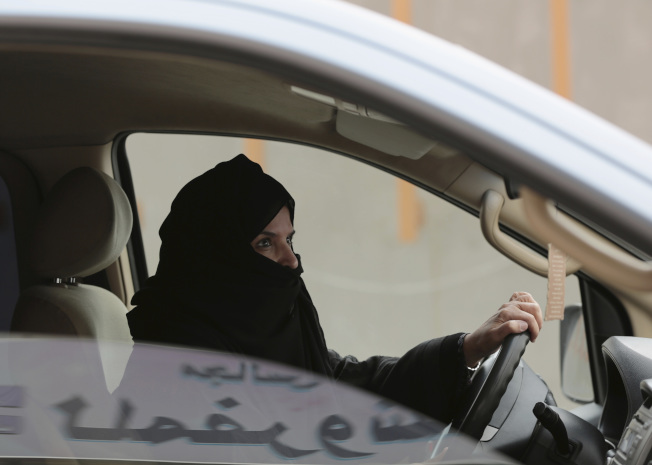 极端保守的沙特阿拉伯首次准许妇女开车上路，图为沙国妇女戴着面纱开车。(美联社)