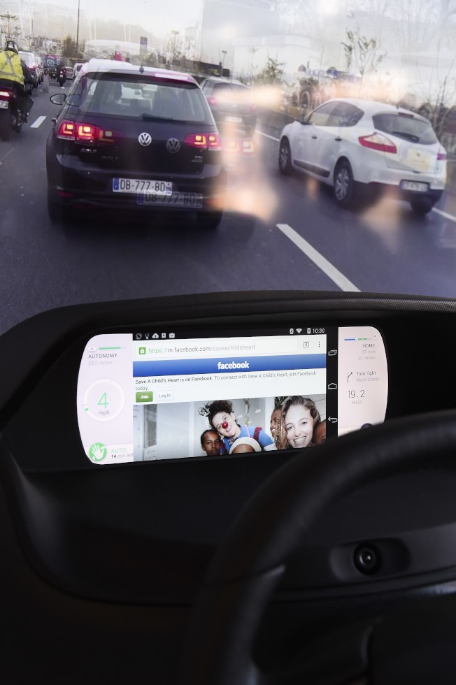 图为一名驾驶人的行车时，使用车上娱乐系统。(Getty Images)